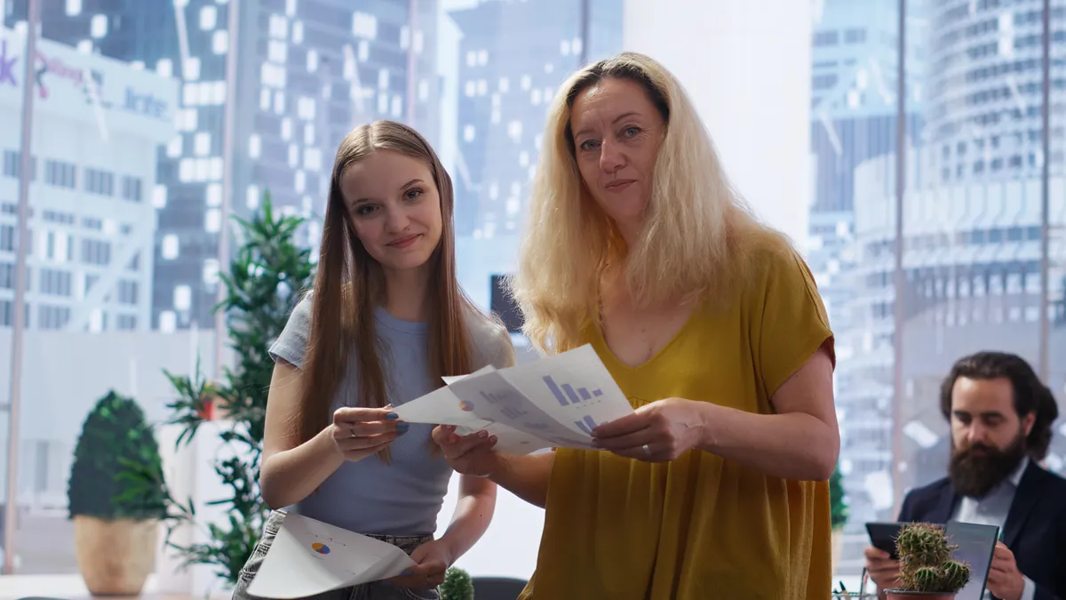 Dos personas sosteniendo documentos junto a un profesional en una oficina